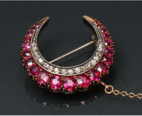 A ruby spinel and diamond crescent brooch, outer graduating row of twenty one oval and cushion cut pinky red rubies and spine