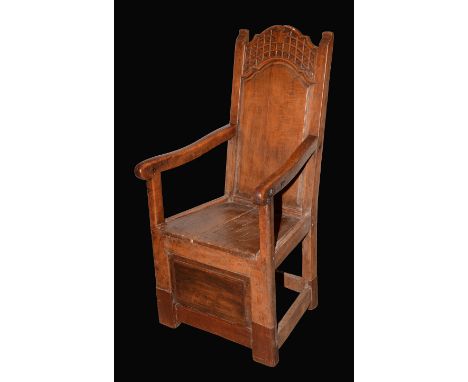 An 18th century continental fruitwood armchair, shaped arched cresting carved with naive anthemions and lattice, outswept scr