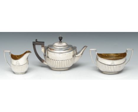 A Victorian silver three piece half-fluted oval tea service, comprising teapot, milk jug and sugar basin, the teapot inscribe