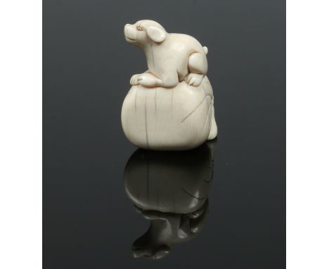 A Japanese Meiji period carved ivory netsuke. Formed as a dog seated upon a large sack, 4.5cm high. Condition Report. To be u