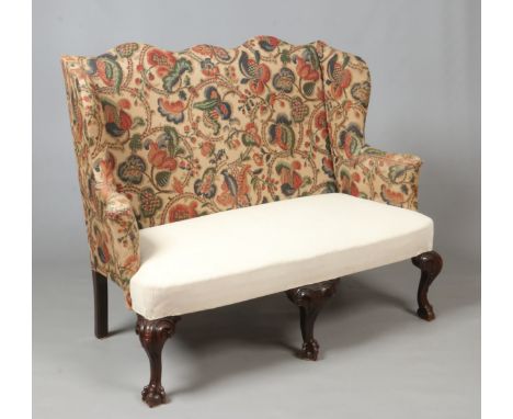 A 19th century Chippendale style upholstered wing arm settee raised on carved mahogany ball and claw supports, 1m 37cm wide, 