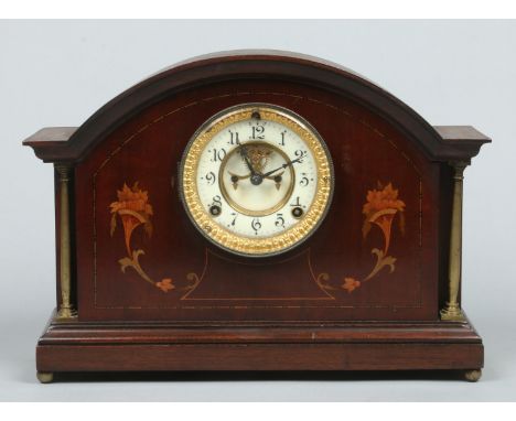 A mahogany cased Ansonia 8 day mantel clock. With brass column supports, marquetry inlay and having enamel chapter ring with 