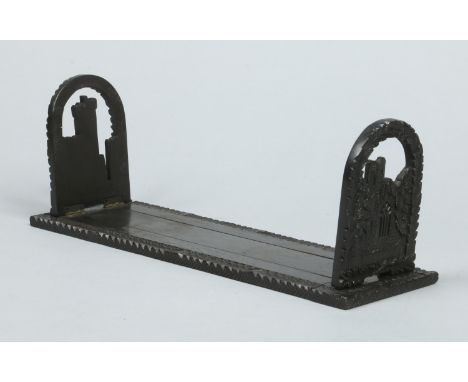 A 19th century Irish carved bog oak book slide. With borders of trailing leaves and decorated to each upright with a castle, 
