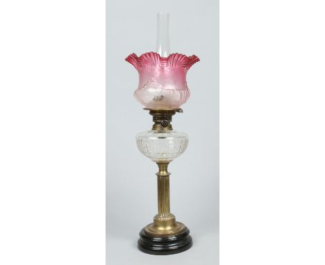 A Victorian brass based oil lamp. With cranberry tint etched lass shade and cut glass font, 70cm. Condition Report. To be use