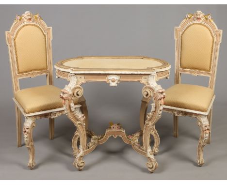 A 19th century Venetian carved, painted and parcel gilt walnut centre table and pair of side chairs. Ornamented with grotesqu