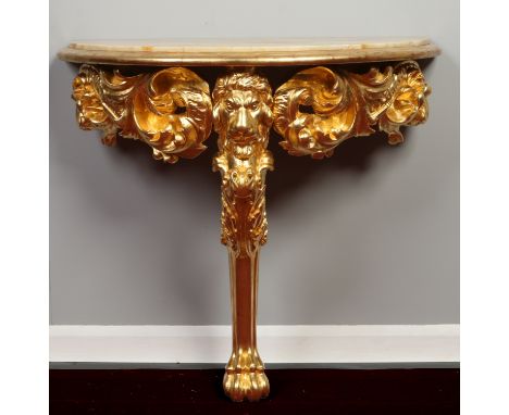 A part 18th century English assembled marble top giltwood console table. With deep scrollwork frieze flanking a central lion 