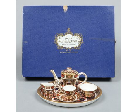 A boxed Royal Crown Derby Imari miniature tea service pattern 1128. Comprising oval cabaret tray, teapot, sugar bowl, milk ju