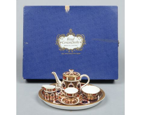 A boxed Royal Crown Derby Imari miniature tea service pattern 1128. Comprising oval cabaret tray, teapot, sugar bowl, milk ju