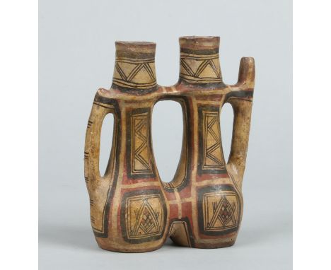 A pre Columbian terracotta flask formed from two conjoined bottles. Decorated in red, black and white enamels with geometric 