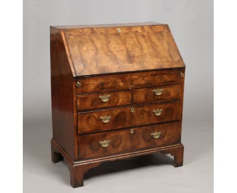 A Georgian figured walnut and oyster veneered bureau. Crossbanded, with fitted interior, oak lined drawers and raised on brac