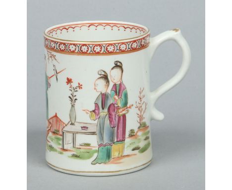 A Lowestoft mug with scrolling handle having kick out terminal. Painted in coloured enamels with a Chinese family in a contin