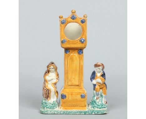 A late 18th / early 19th century prattware pocket watch holder. Modelled in the form of a longcase clock and flanked by a pai