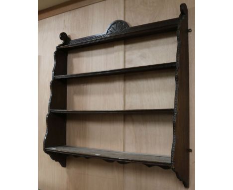 An Edwardian carved oak four shelf wall bracket, W.100cm