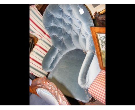 An antique button back easy chair on castors 