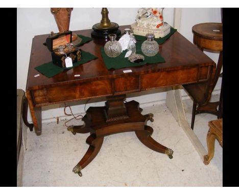 A Regency sofa table on shaped support with two drawers to the front and cross banded top 