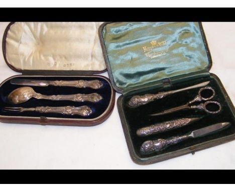 A silver knife, fork and spoon set in presentation case, together with a cased manicure set