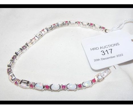 A silver opal and ruby bracelet