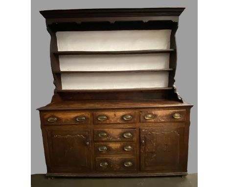 CIRCA 1760 CONWY VALLEY OAK DRESSER having a pot belly shape three shelf rack with wide back boards, over a three plank base,