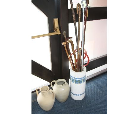 A CERAMIC STICK STAND, containing various walking sticks, carpet beater etc and two stoneware items (3)