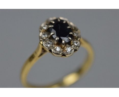 A MID TO LATE 20TH CENTURY 18CT GOLD SAPPHIRE AND DIAMOND OVAL CLUSTER RING, estimated total diamond weight 0.10ct, ring size