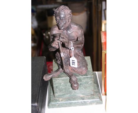 A CAST MYTHICAL FIGURE OF A FAUN, seated playing musical instrument, height approximately 22cm, on a stepped marble plinth 