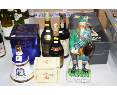 A COLLECTION OF THREE BOTTLES OF WHISKIES, two bottles of Brandy and a bottle of Port, the whiskies comprise of Bells in a co