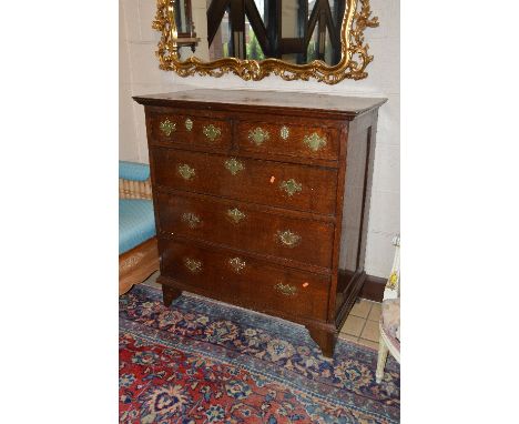 A GEORGIAN OAK CHEST, of two short and three long drawers with brass handles and escutcheons on replaced bracket feet, approx