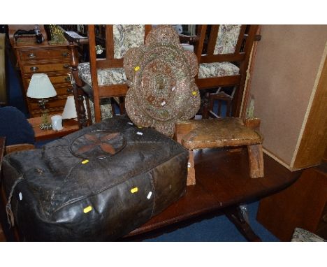 AN EASTERN STYLE BRASS AND COPPER WALL PLAQUE, a leather straw filled pouffe and a pine camel stool (3)