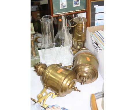 A PAIR OF BRASS WALL MOUNT OIL LAMPS WITH FOUR VARIOUS GLASS CHIMNEYS, together with a brass miners lamp (7)