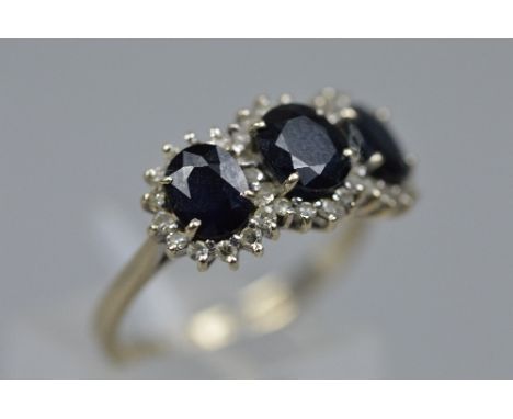 A MID TO LATE 20TH CENTURY SAPPHIRE AND DIAMOND TRIPLE CLUSTER RING, estimated total diamond weight 0.30ct, sapphires measuri