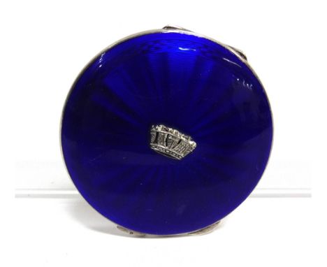 AN ENGINE TURNED SILVER AND ENAMEL ROUND COMPACT OF NAVAL INTEREST  the hinged cover guilloche enamelled in navy blue and cen