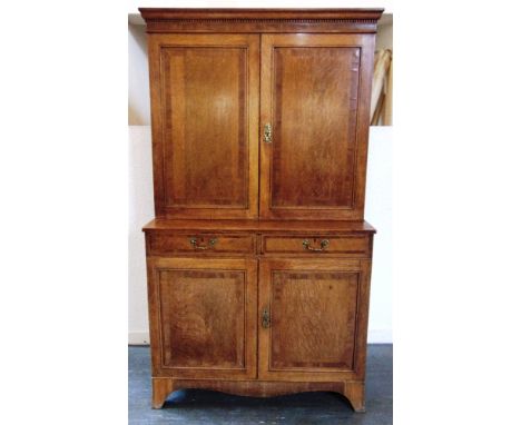 AN OAK SIDE CABINET WITH MAHOGANY CROSSBANDED DECORATION  the dentil frieze above cupboard opening to adjustable shelves, the