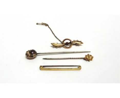 AN EARLY 20TH CENTURY GOLD AND TINY DIAMOND STICK PIN stamped '15ct'; a gold and garnet stick pin (base pin); and two gold br