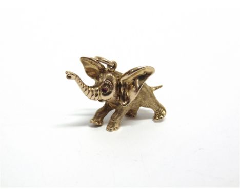 AN MODERN 9CT GOLD ELEPHANT PENDANT resembling Dumbo in a joyful and playful pose with his trunk raised and with a synthetic-