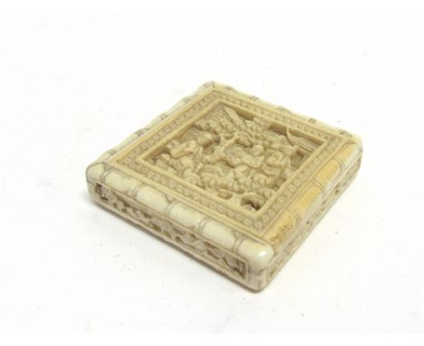 A CHINESE CARVED IVORY BOX  6cm square, the sliding lid opening to reveal seven piece geometric puzzle