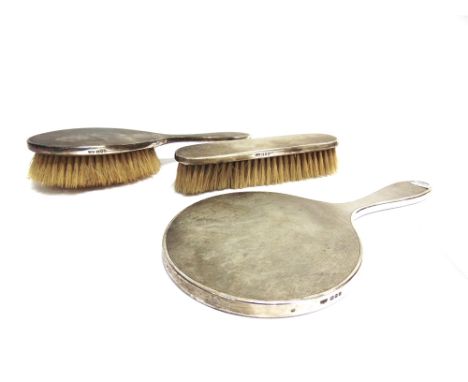 A SILVER ENGINE TURNED THREE PIECE DRESSING TABLE SET  comprising a round hand mirror, an oval chair brush and an oblong clot