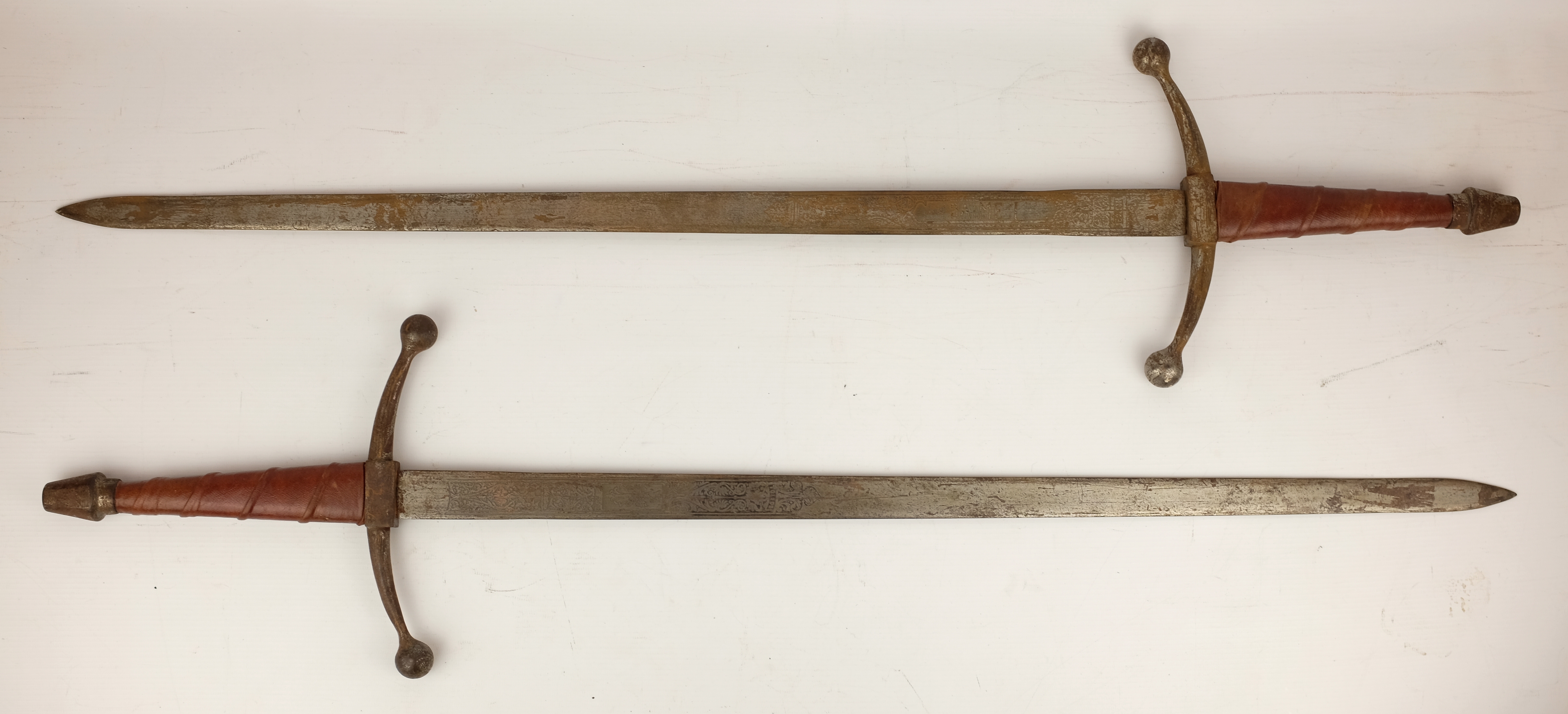 Pair of ornamental Spanish type swords with leather bound grips, 69cm