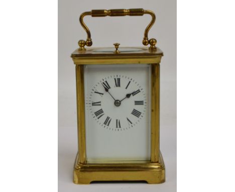 A late 19th century French brass cased repeating carriage clock, the swing loop handle above white enamel rectangular dial se