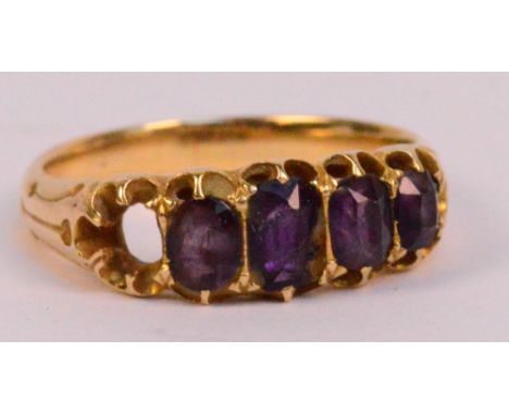 A yellow metal five stone dress ring set with four graduated amethyst coloured faceted stones (one missing and one af), size 