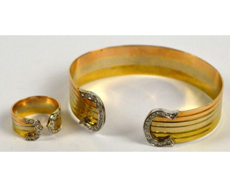 An 18ct three tone gold bangle with linear decoration and rounded terminals, each set with 18ct round cut diamonds, oval 6.5 