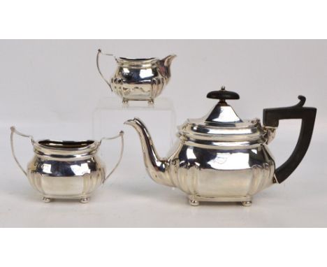 A late Victorian hallmarked silver three piece bachelor's tea set comprising an oval teapot with fluted decoration to lower p