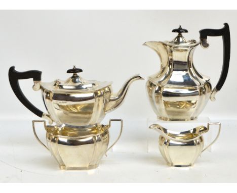 A George V hallmarked silver four piece matched tea set comprising a teapot of shaped oval form with fluted corners, length i