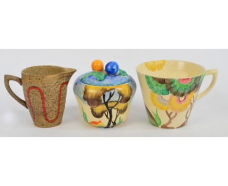 A Newport Pottery Clarice Cliff preserve pot and cover decorated with a tree beside an orange roof cottage, printed marks to 