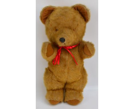 A vintage musical clockwork brown teddy bear with wind-up key to the back, playing Brahms' Lullaby, length 46cm.