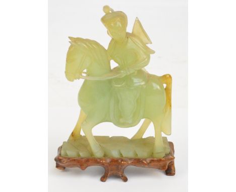 A Chinese carved jade figure of a female upon horseback raised on a shaped carved wooden base, height 21.25cm.