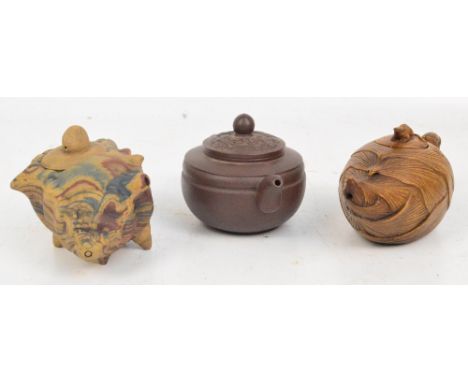 A 20th century Chinese Yixing teapot with cover, mould decorated with dragon and phoenix, length 15cm, a further ceramic lotu