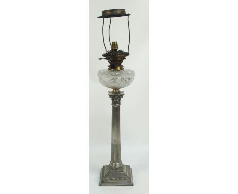 An electroplated oil lamp with clear cut glass reservoir on Corinthian column stem above square stepped base, with brass fitt