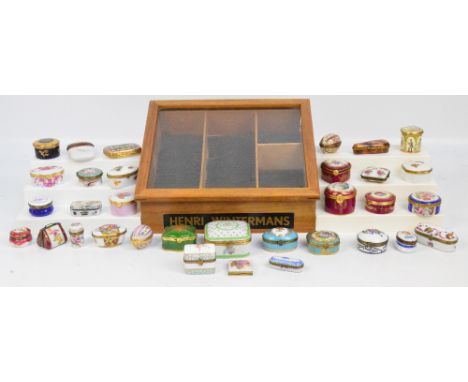 A quantity of decorative modern porcelain trinket boxes contained within a vintage Henry Wintermans glass fronted sloping dis