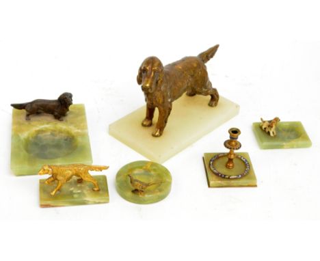 A green onyx ashtray surmounted by a spelter model of a dog, a similar smaller example, an onyx and enamel decorated candlest