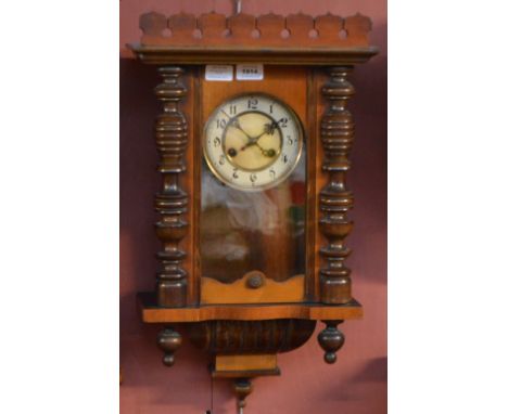 An early 20th century eight day wall clock, the circular dial set with Arabic numerals flanked by two ring turned columns, he